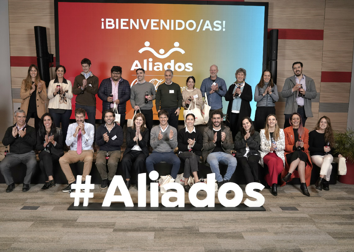 Grupo de personas sonrientes, aplaudiendo en un evento de 'Aliados' en Argentina.