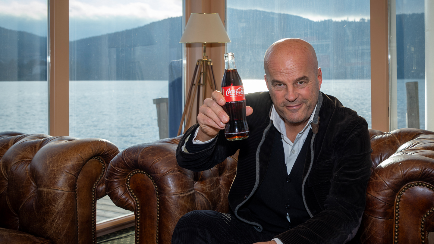 Selfmade-Unternehmer Martin Ramusch mit Coca-Cola Flasche in Hand