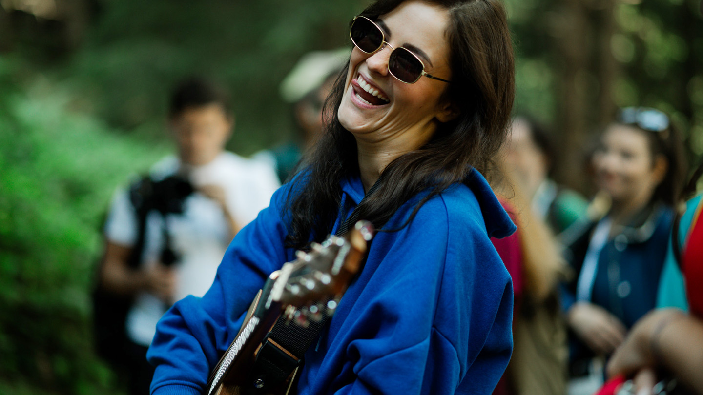 lachende Frau mit Gitarre in Hand