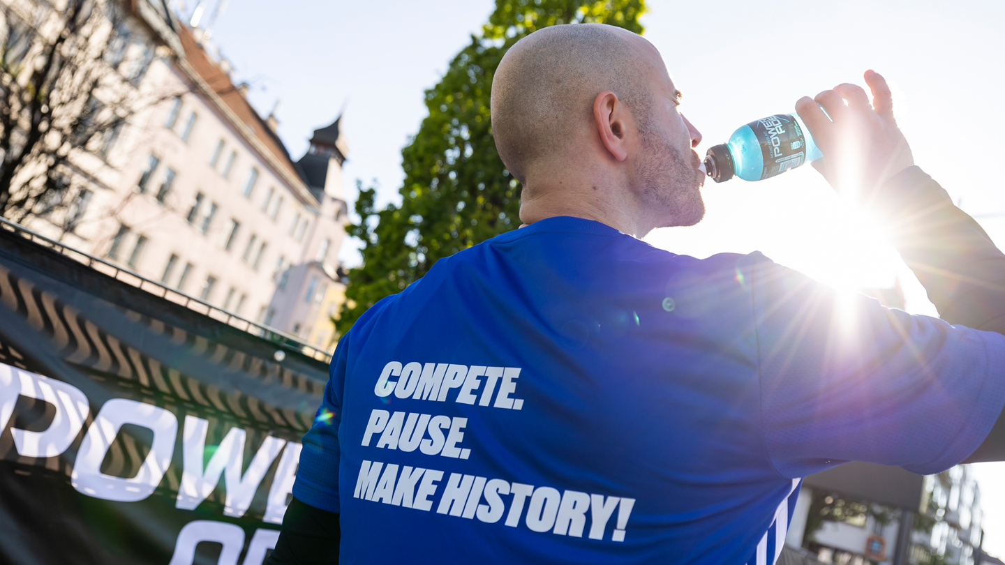 Teilnehmer des Vienna City Marathons trinkend mit Powerade Flasche in Hand