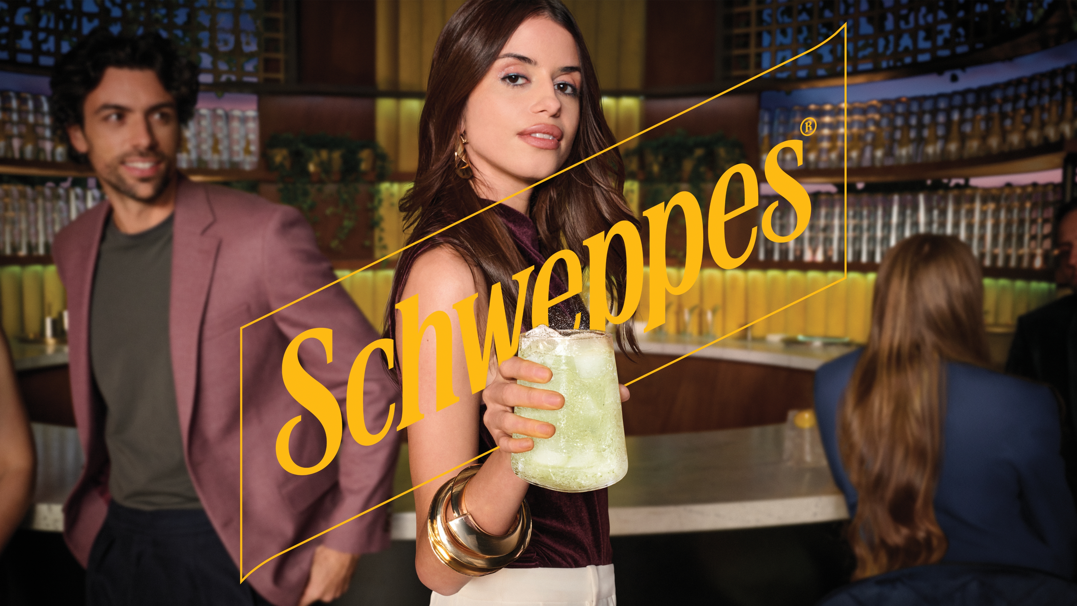 Djevojka pruža Schweppes piće u staklenoj čaši u baru