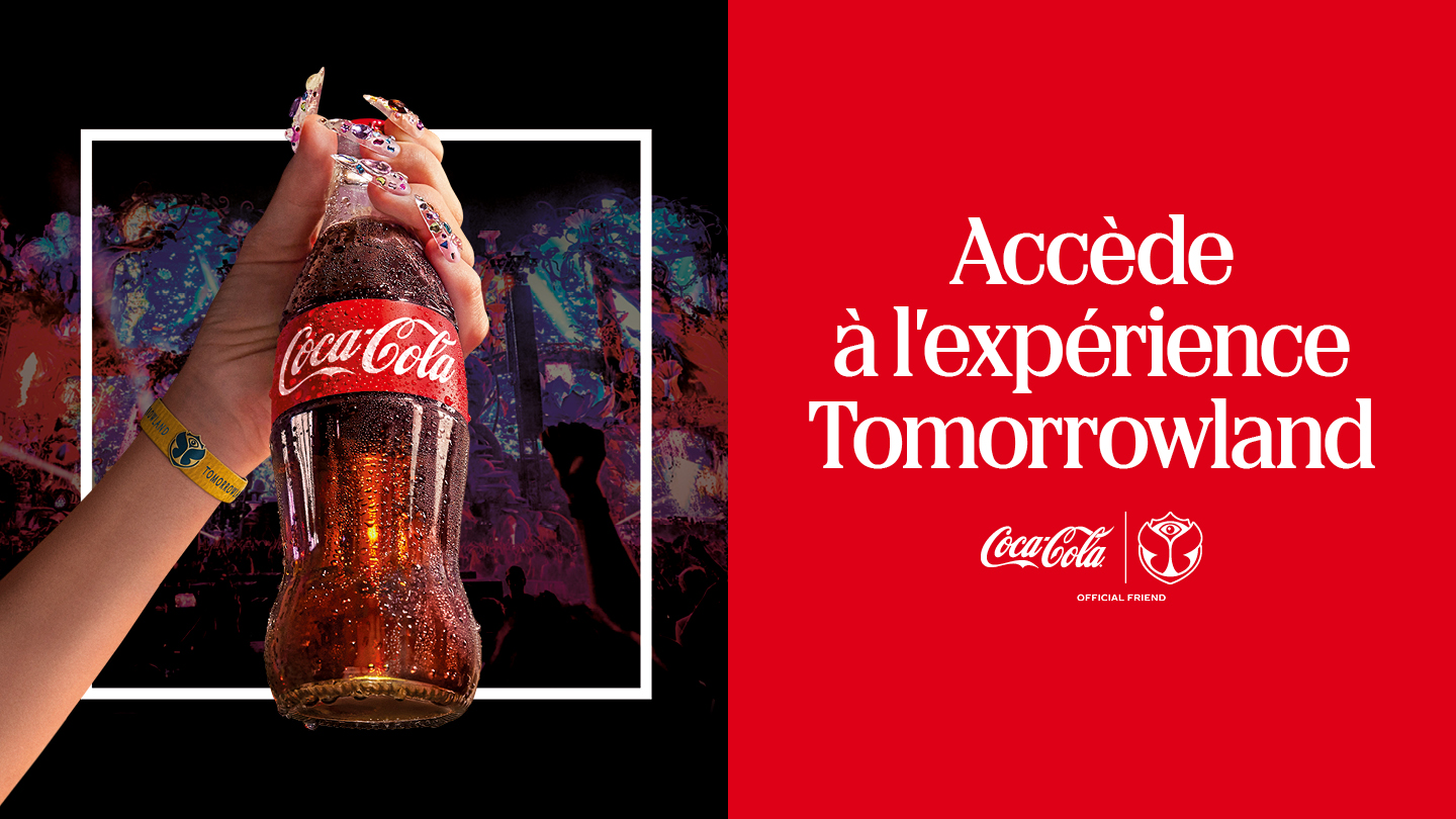 Une main brandit une bouteille en verre de Coca‑Cola devant une scène de festival lumineuse et animée ; à droite, un fond rouge affiche le texte « Accède à l’expérience Tomorrowland » avec les logos Coca‑Cola et Tomorrowland en dessous.