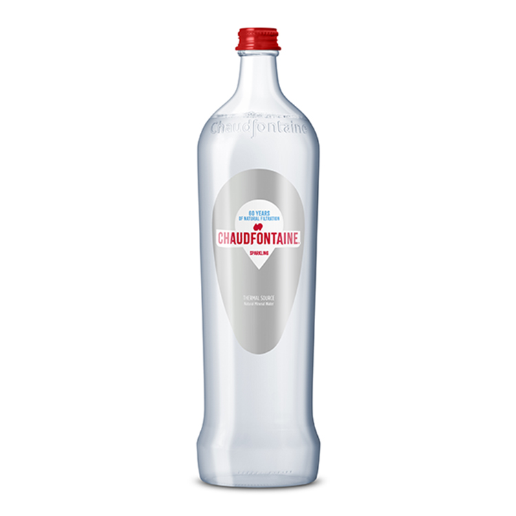 Bouteille en verre transparente d’eau minérale naturelle pétillante Chaudfontaine, avec bouchon rouge et étiquette indiquant « 60 years of natural filtration – Sparkling ».