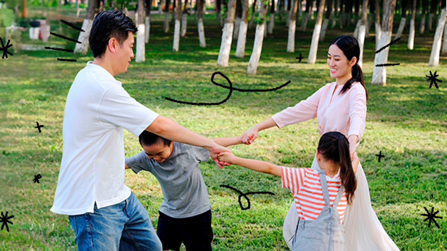 Família brincando juntos ao ar livre, de mãos dadas em círculo.