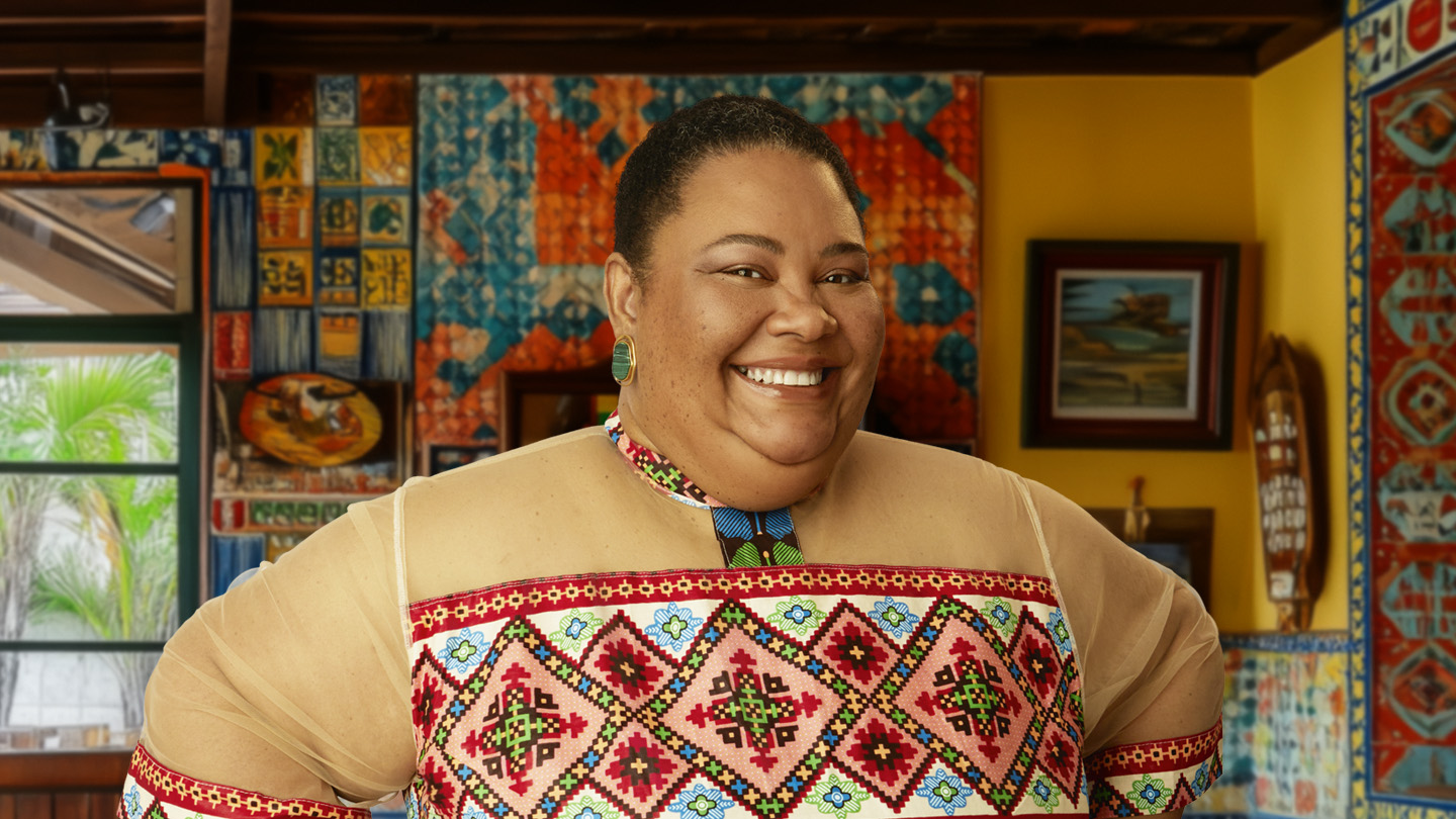 Mulher sorridente com blusa bordada e brincos, em ambiente com arte colorida.