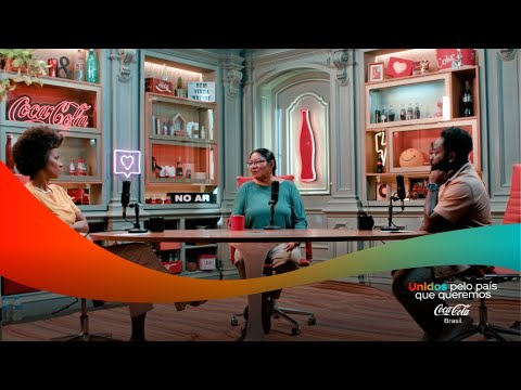 Três pessoas em um estúdio de podcast, com prateleiras cheias de itens da Coca-Cola ao fundo.