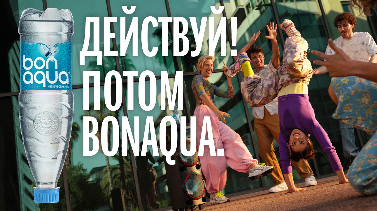 Людзі танцуюць на вуліцы перад будынкам з калонкай і Bonaqua