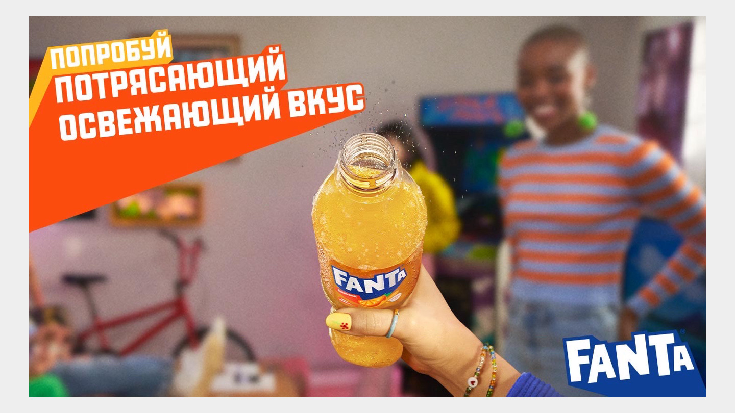 Рука трымае бутэльку Fanta з іскрыстым напоем