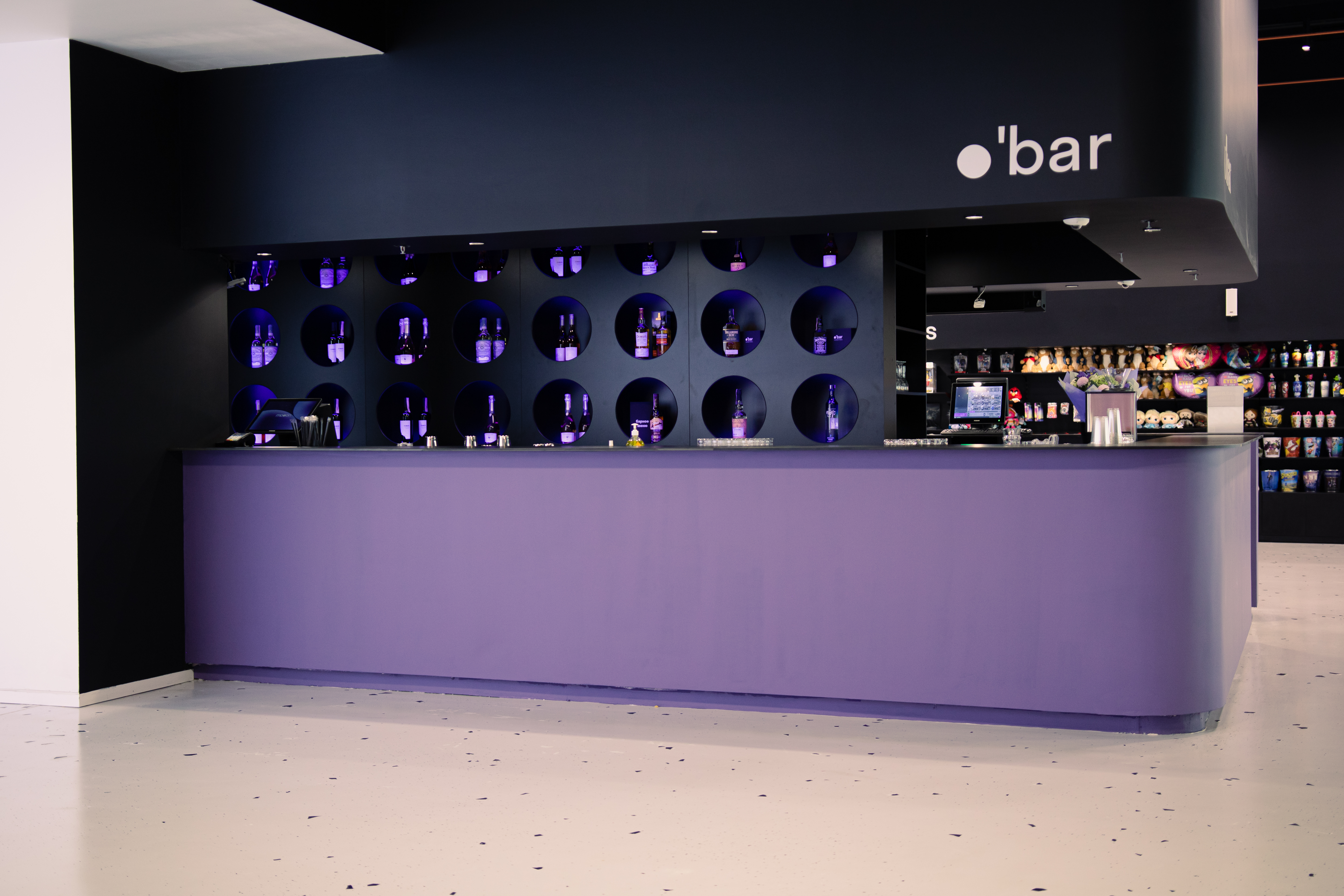 Фіялетавы бар з бутэлькамі ў круглых нішах і сучасным дызайнам