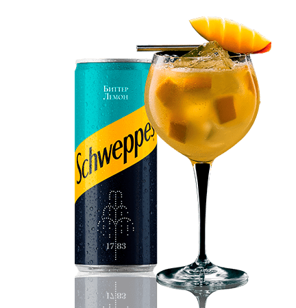 Банка Schweppes Бітэр Лемон побач з жоўтым кактэйлем і долькай манга