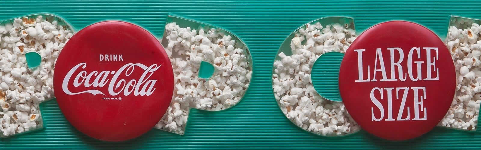 Coca-Cola Werbung mit Popcorn als Schriftzug