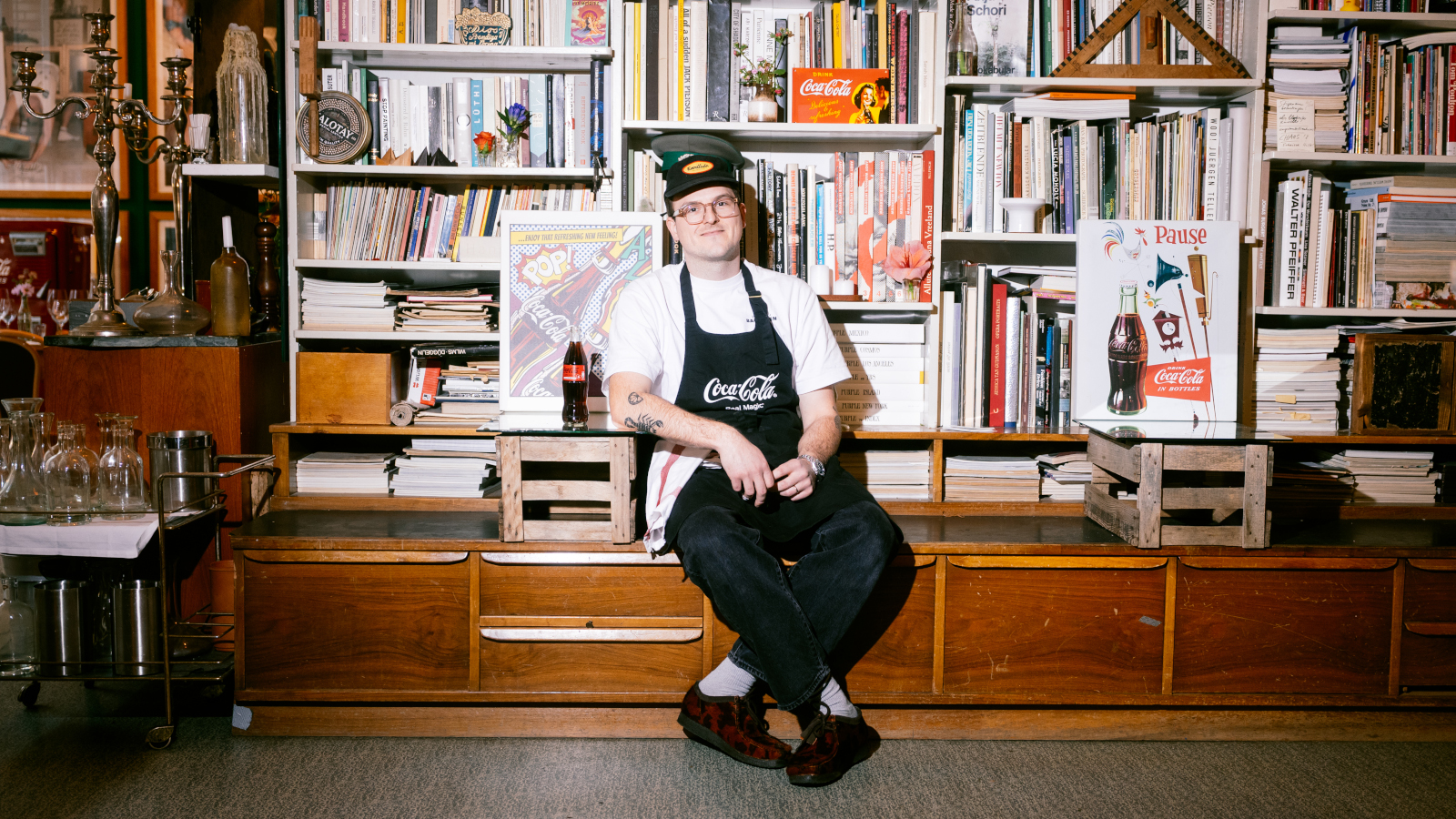 Noah Bachofen sitzt vor einem Bücherregal