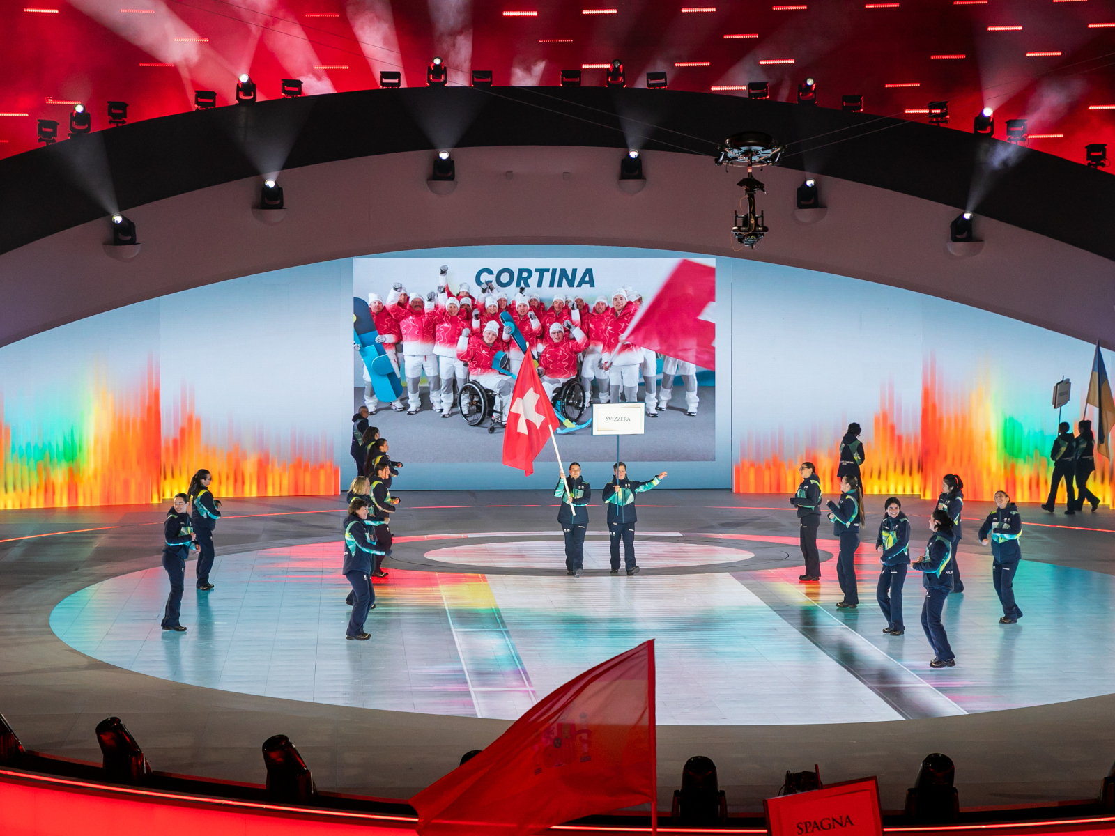 Flavio mit Fahnenträgerin an der Eröffnungsfeier der Paralympics Winterspiele in Verona auf der Bühne