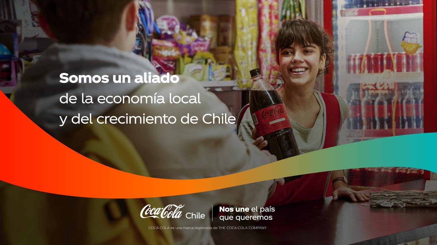 Joven sonriente atendiendo en un almacén, entregando una botella grande de Coca-Cola a un cliente.