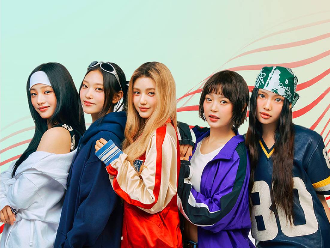 NewJeans posando frente a un fondo con ondas de colores, luciendo atuendos coloridos y modernos.