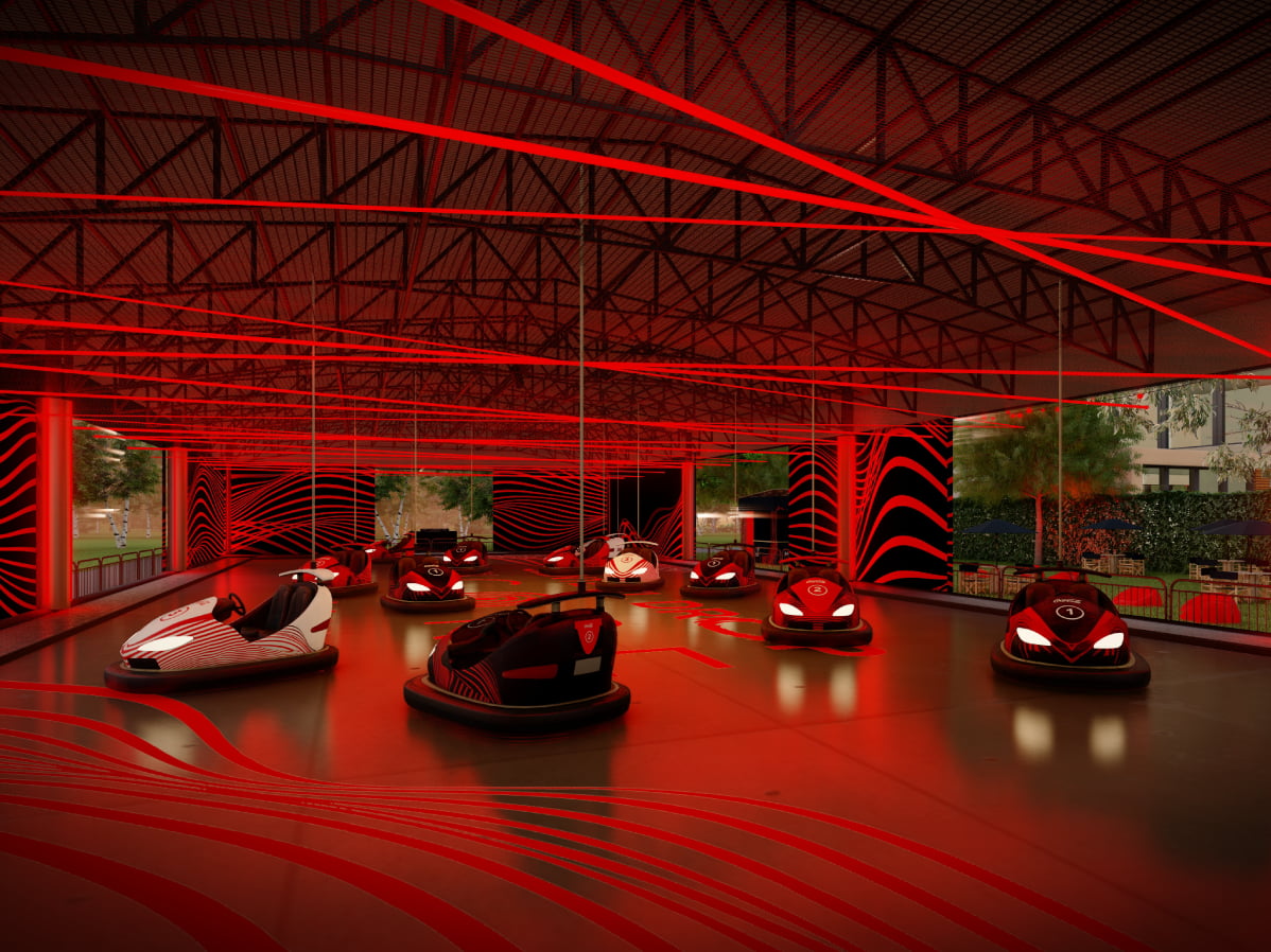 Carritos chocones sobre una pista iluminada con luces rojas.