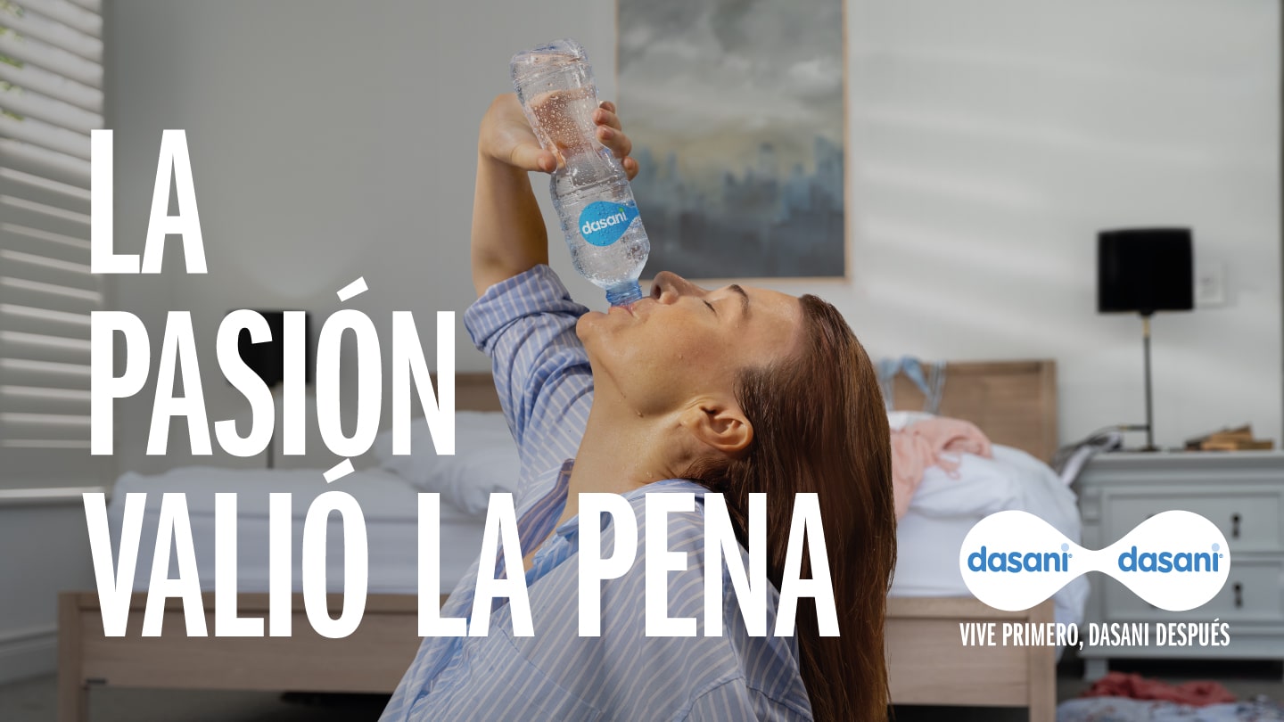 Una mujer bebe de una botella de Dasani