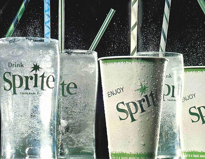 Külmad Sprite joogid läbipaistvates klaasides ja paberist topsis kõrtega, jook mullitamas.