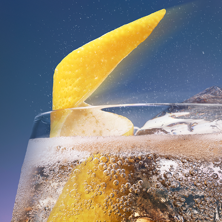 Klaas kihiseva Schweppes joogiga, milles on jääkuubikud ja sidrunikoor.