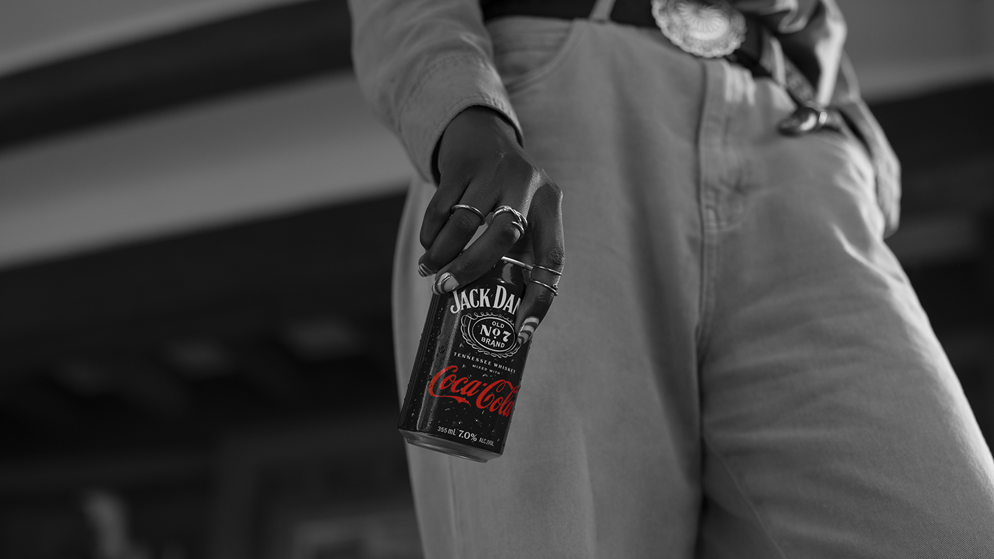 Dorë duke mbajtur një kanaçe Jack Daniel’s dhe Coca-Cola.
