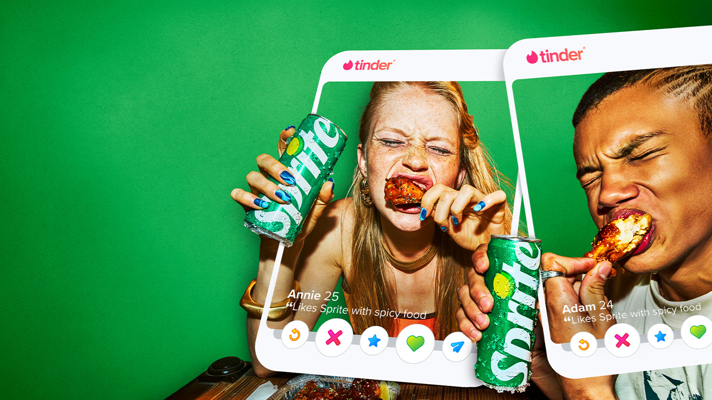 Promotionele afbeelding met een Tinder-profielkaart van een persoon die een groen Sprite-blikje omhooghoudt aan een tafel met pittig eten. De scène heeft een groene achtergrond en benadrukt de samenwerking tussen Sprite en Tinder met een speelse, energieke sfeer.