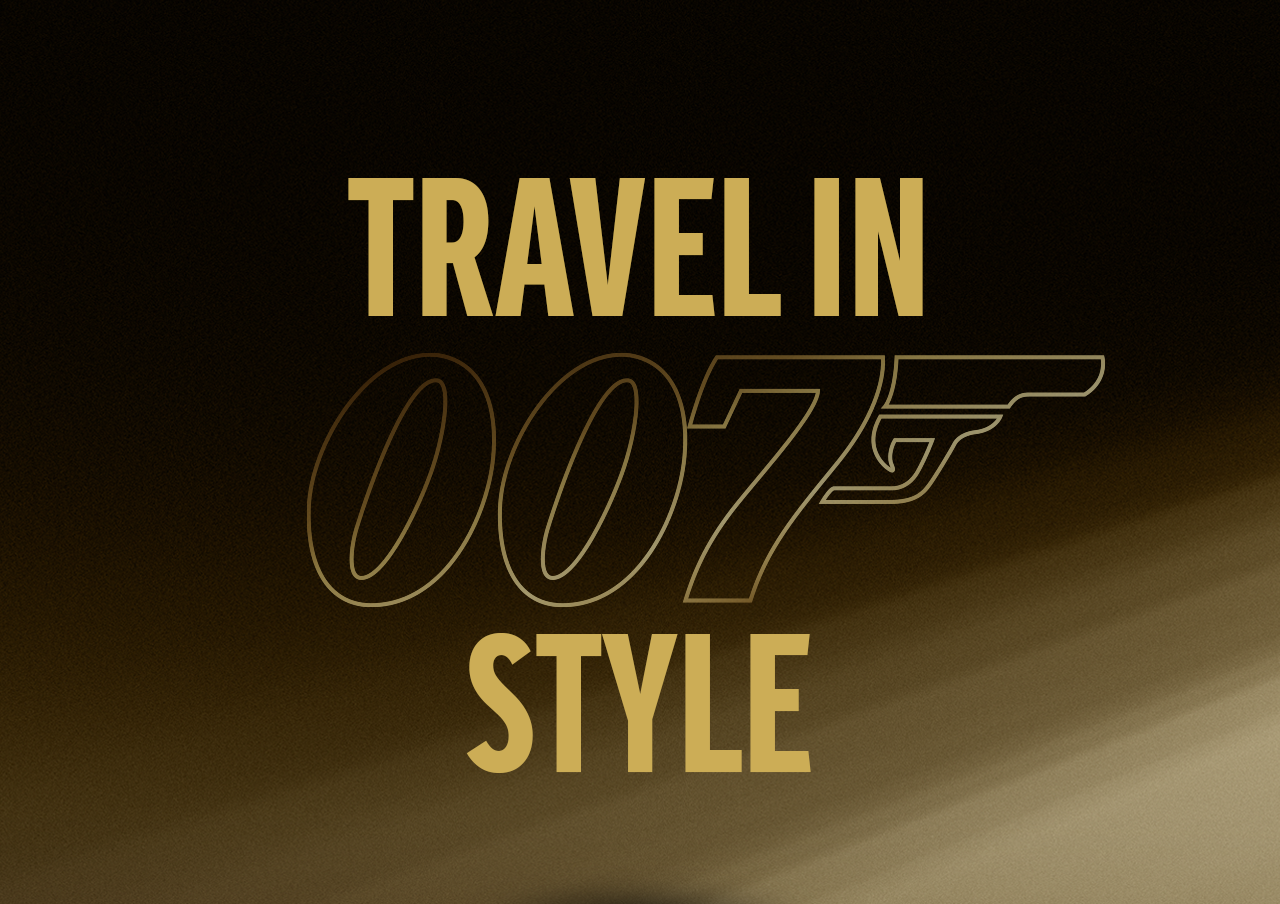 Goudkleurige afbeelding met de tekst “Travel in 007 style” en een gestileerd 007‑logo op een donkere achtergrond.