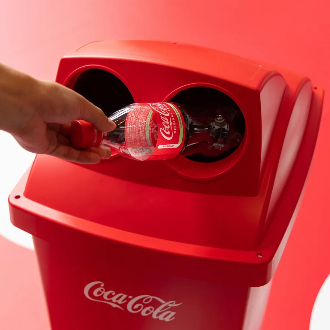 写真：コカ･コーラのペットボトルをリサイクル用のコカ･コーラのゴミ箱に入れている様子