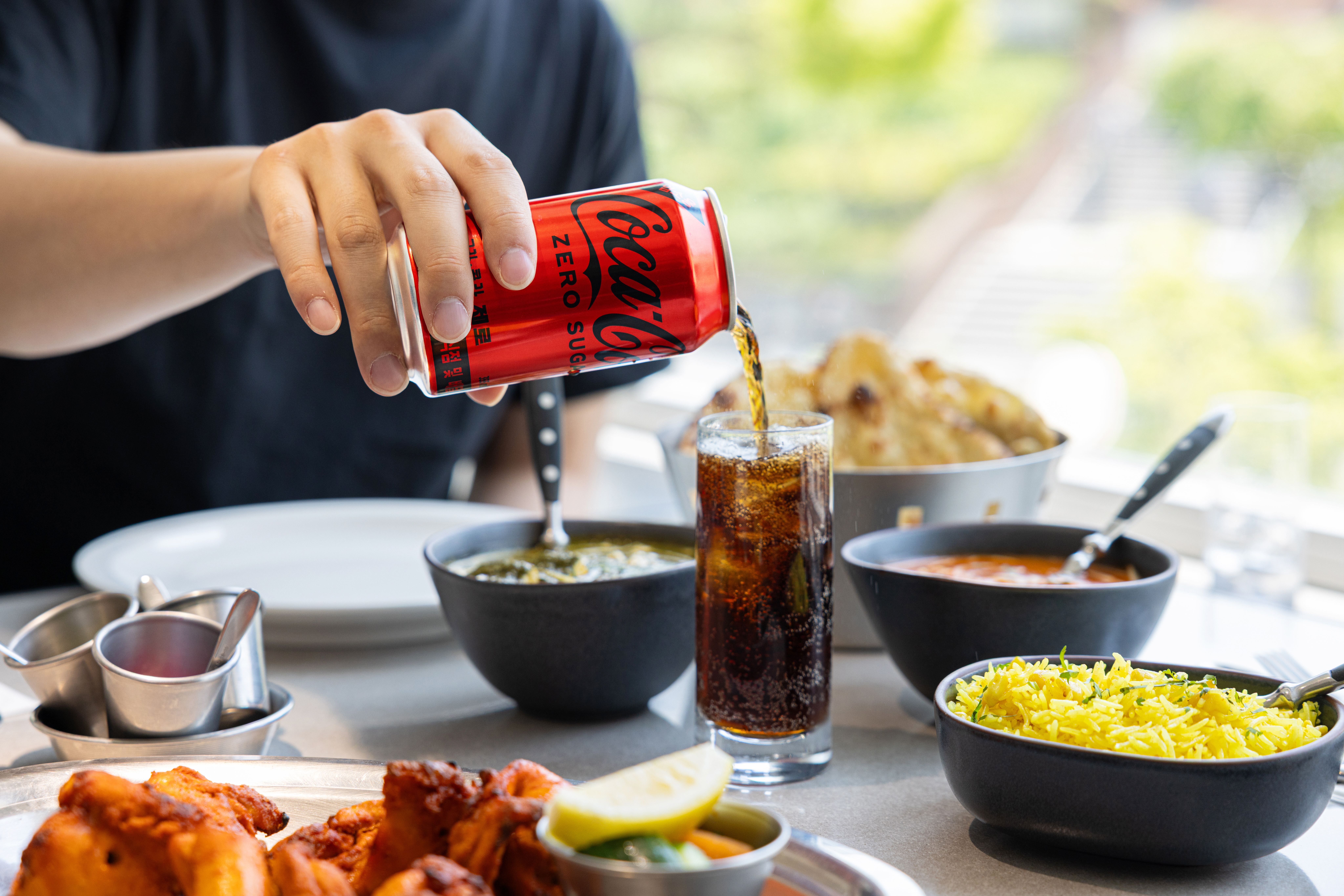 레스토랑 '타지'의 대표 메뉴들과 코카-콜라 제로를 컵에 따르는 사진