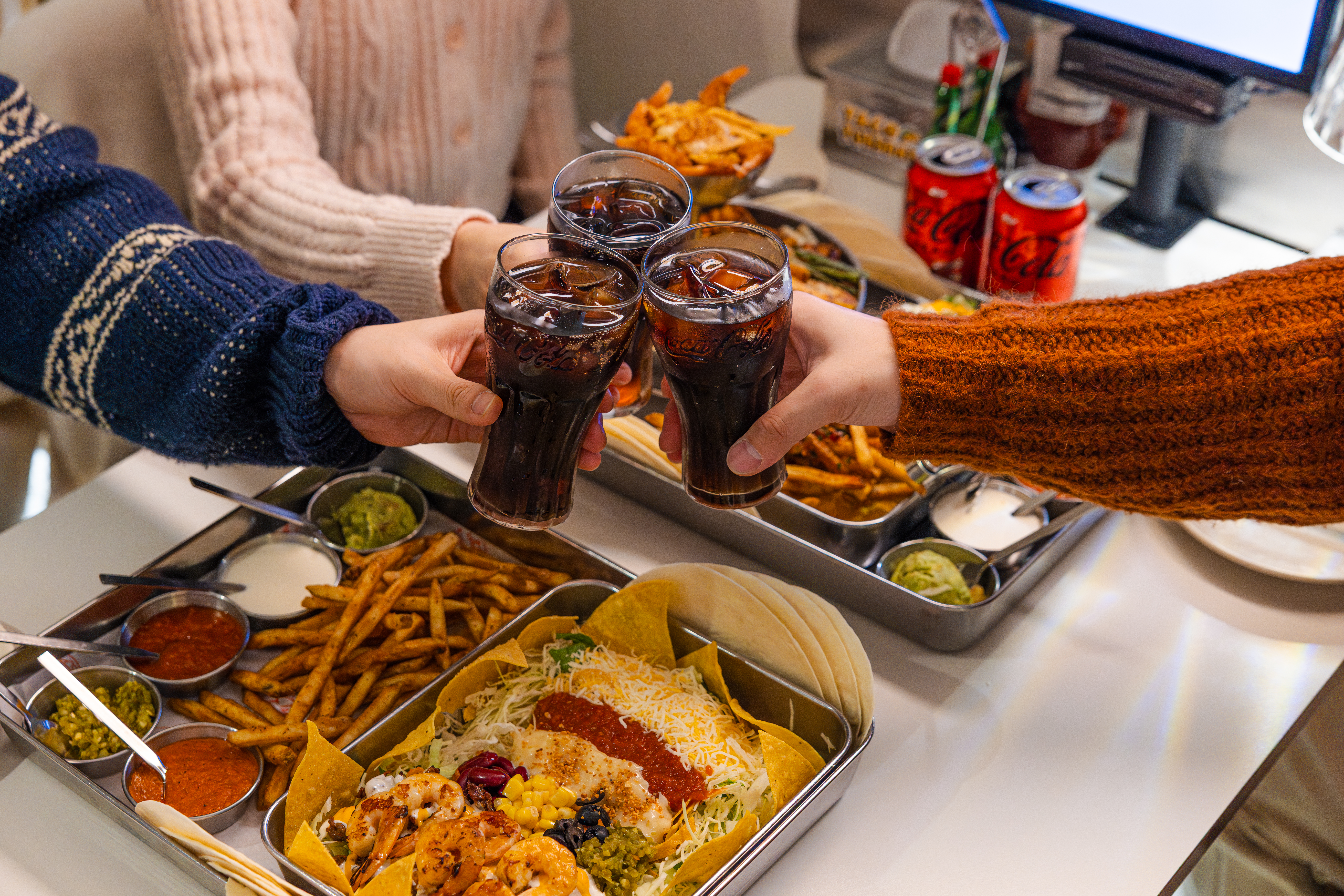 '타코튜즈데이'의 대표 메뉴들과 코카-콜라 제로를 즐기고 있다.