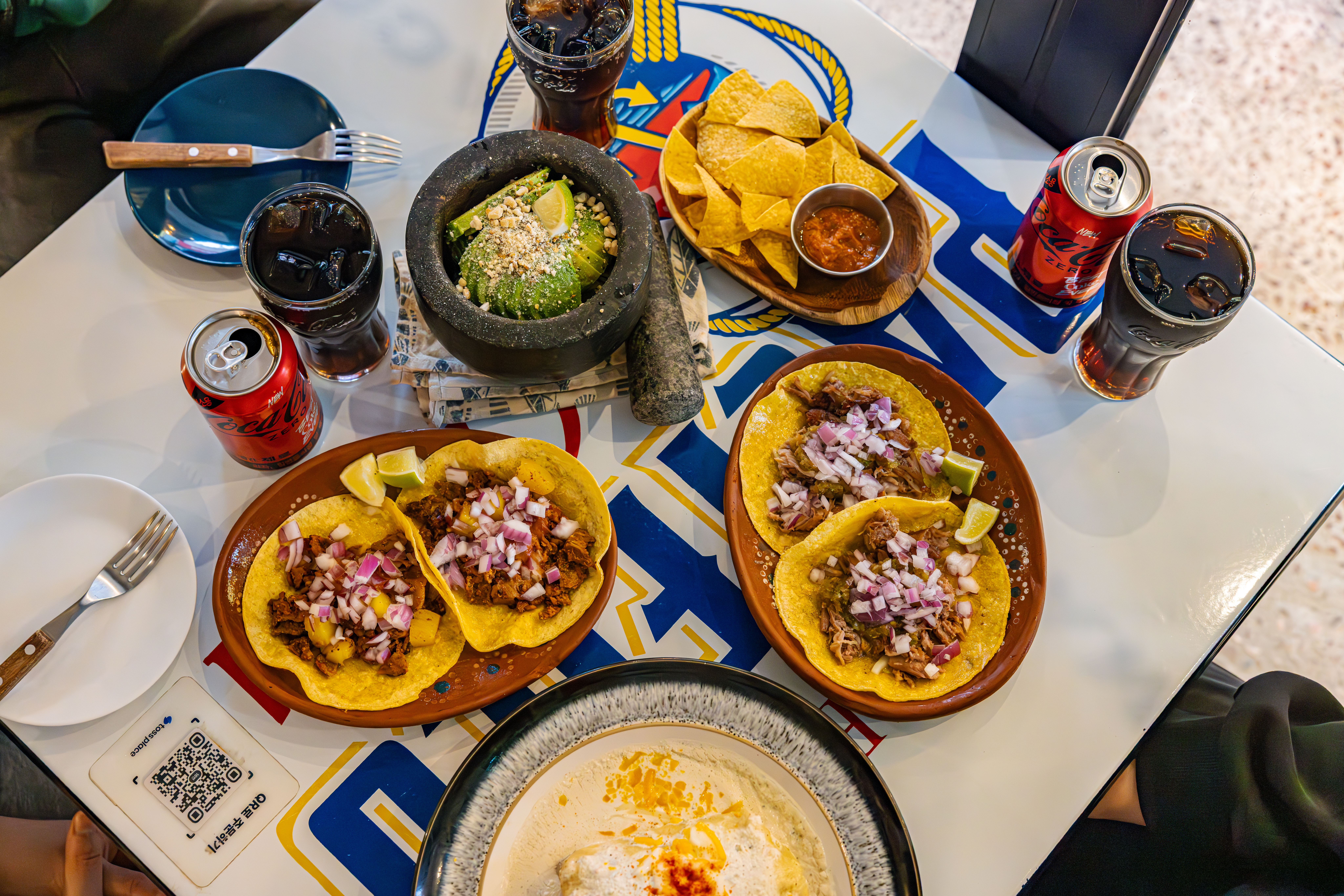 레드리본 맛집 '비아메렝게'의 대표메뉴, 카르니타스 타코, 프레쉬 과카몰리, 그리고 엔칠라다를 코카-콜라 제로와 함께 즐기고 있다.