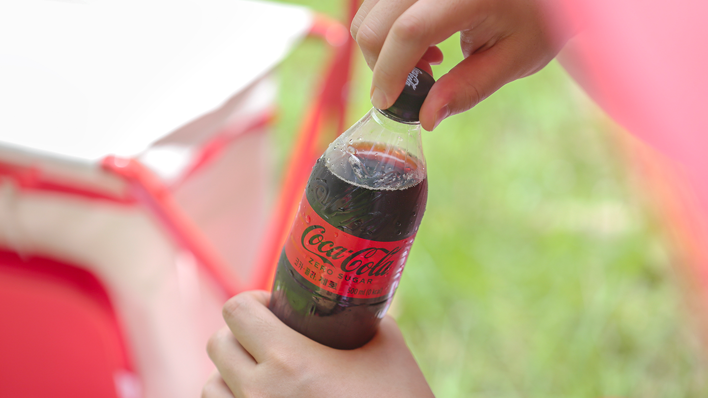 코카-콜라를 마시기 위해 페트병 병뚜껑을 열고 있는 이미지