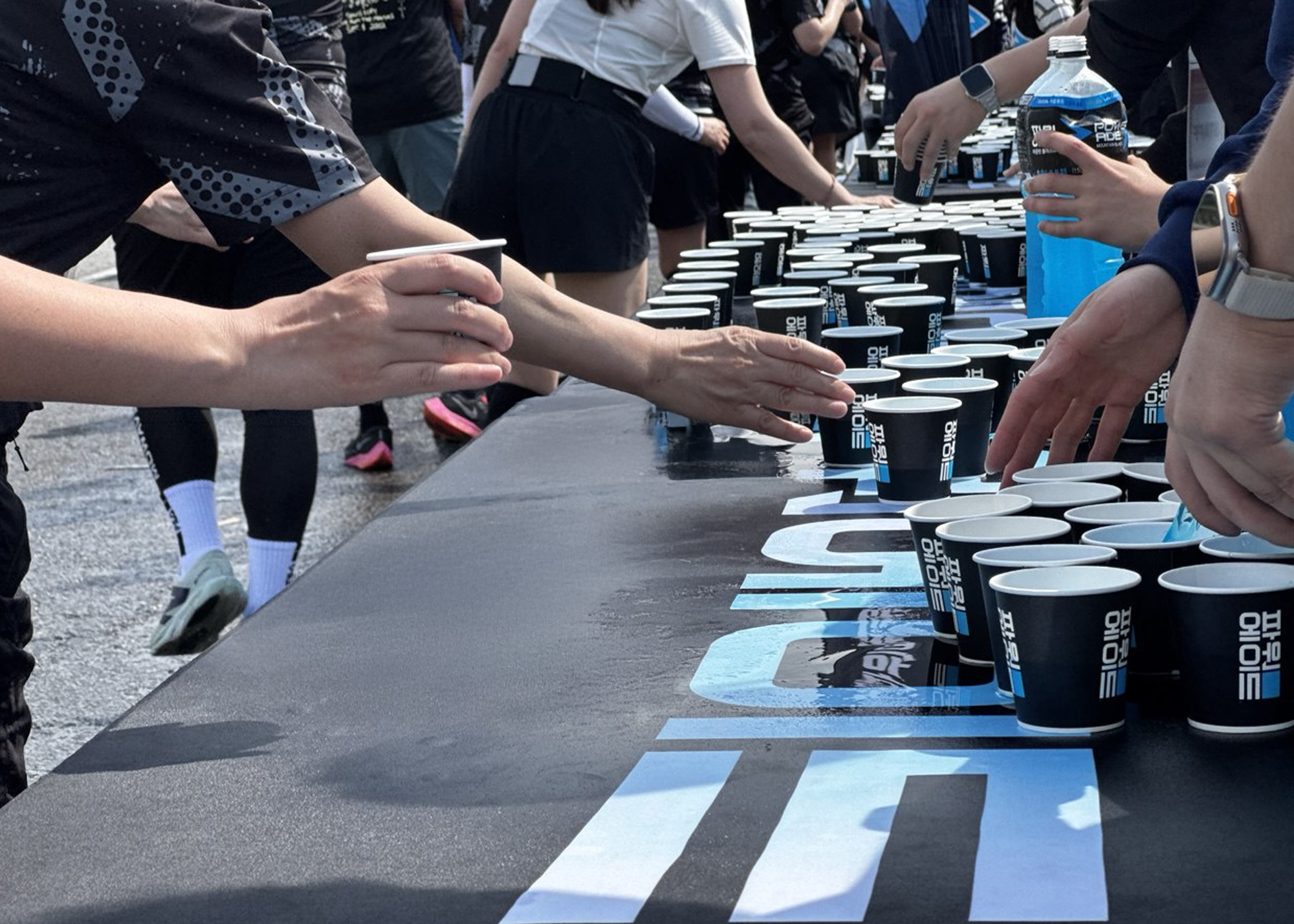 파워에이드 쿨링존에서 파워에이드를 가져가는 마라토너들