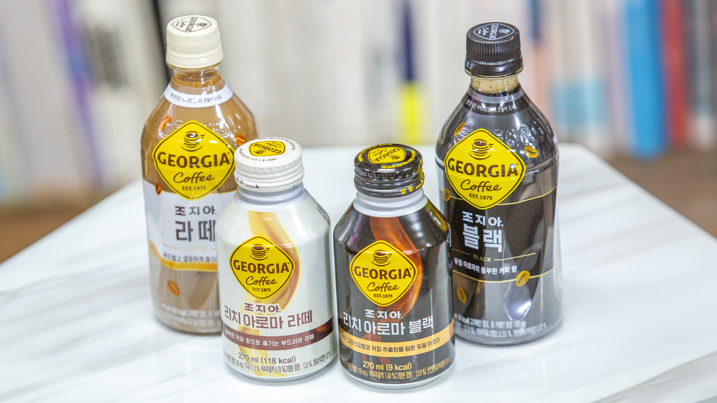 미라클 모닝을 부르는 단 하나의 커피, 조지아!의 대표 이미지로 노랑색으로 새롭게 리뉴얼된 로고가 새겨진 조지아 제품들이 놓여 있다. 왼쪽부터 조지아 라떼, 조지아 리치 아로마 라떼, 조지아 리치 아로마 블랙, 조지아 블랙 제품.