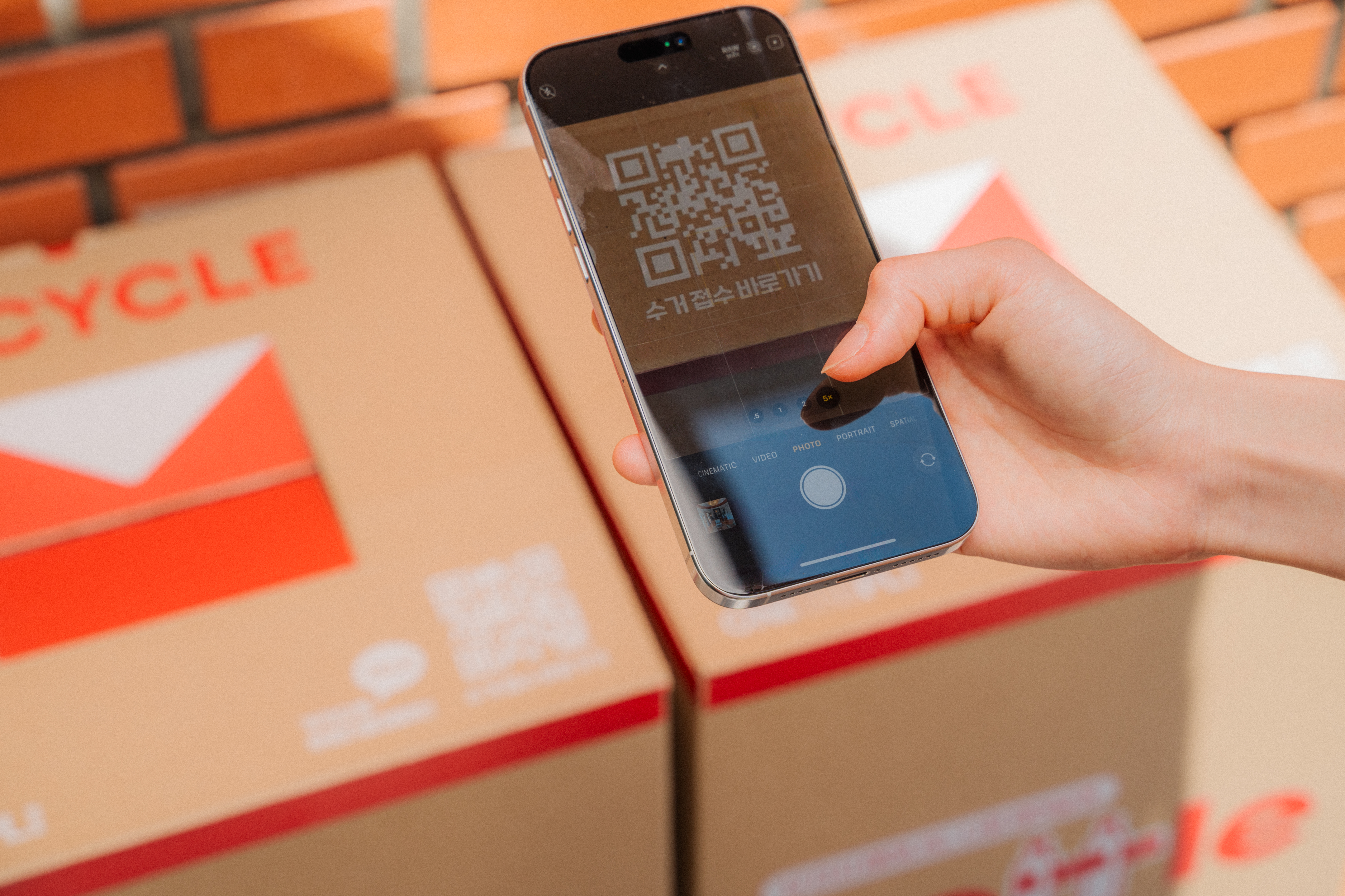 다 채워진 제로 웨이스트 박스를 수거 신청하기 위해 박스 위 QR 코드를 촬영하고 있는 모습