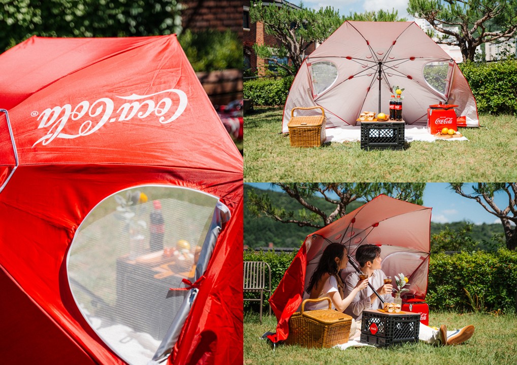 잔디밭에 원더플 우산 텐트를 설치해놓고 피크닉을 즐기고 있는 두 남녀의 모습