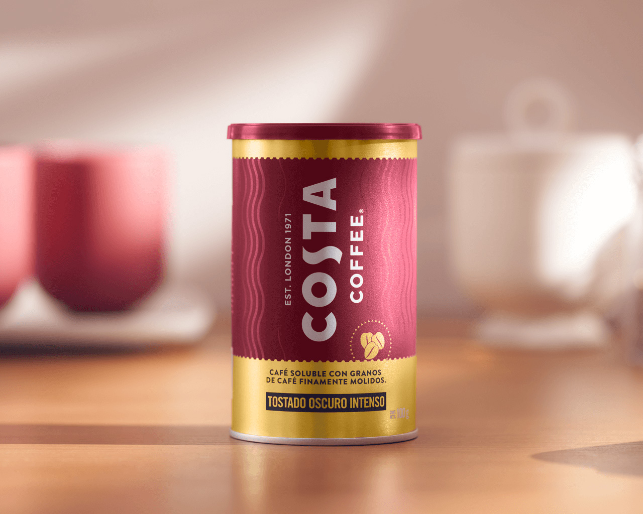 Lata de café soluble Costa Coffee sobre una mesa de madera.