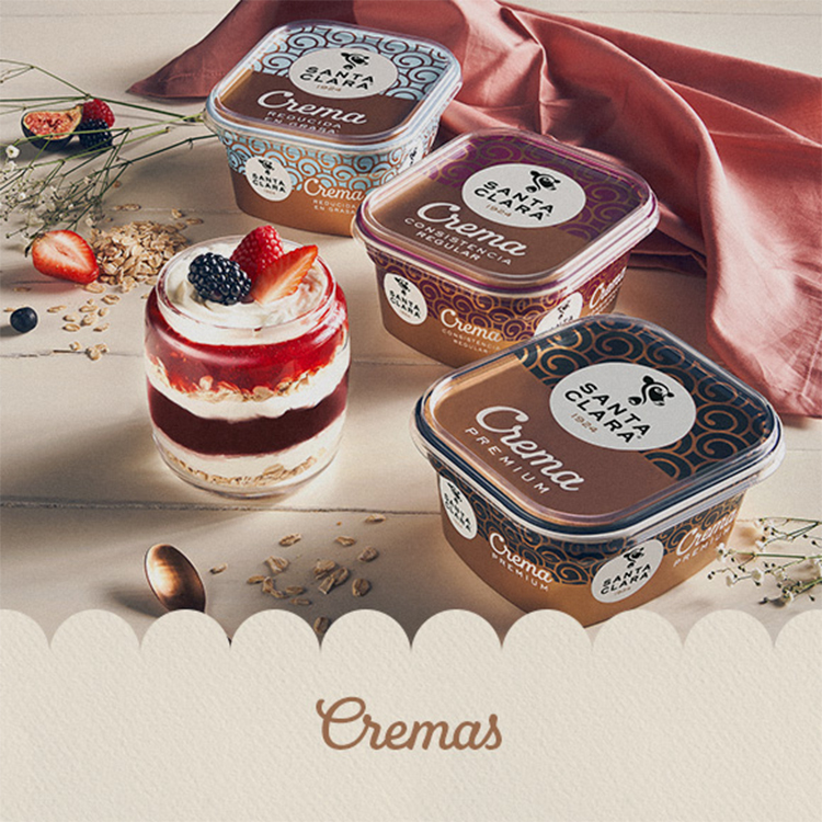 Envases de crema Santa Clara con distintos tipos (premium, regular, exquisita), acompañados de un postre en vaso con capas de crema, fruta y avena.