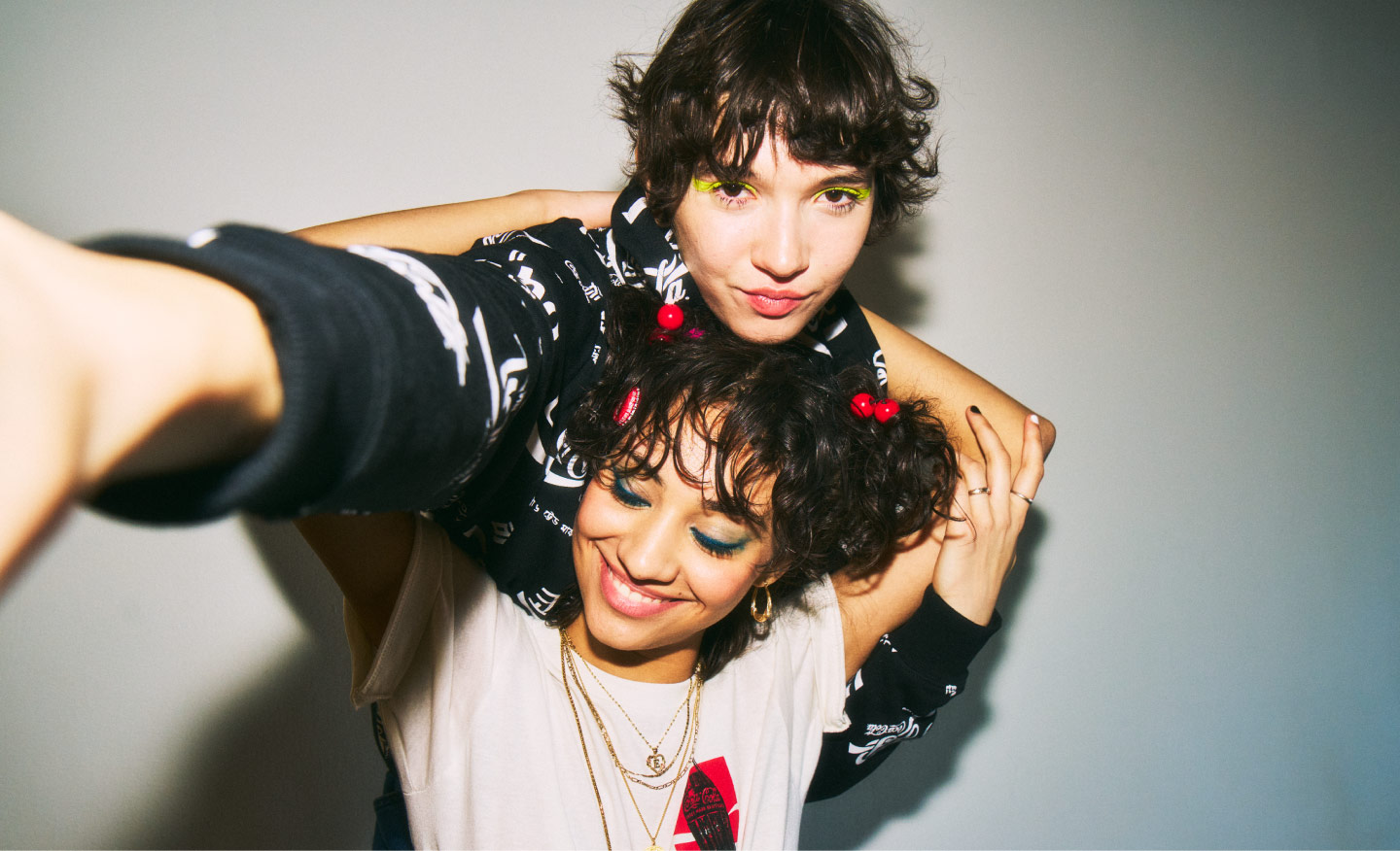 Dos personas jóvenes posan sonrientes durante una experiencia en House of Coca-Cola Masaryk, Polanco, en un ambiente casual y creativo.​