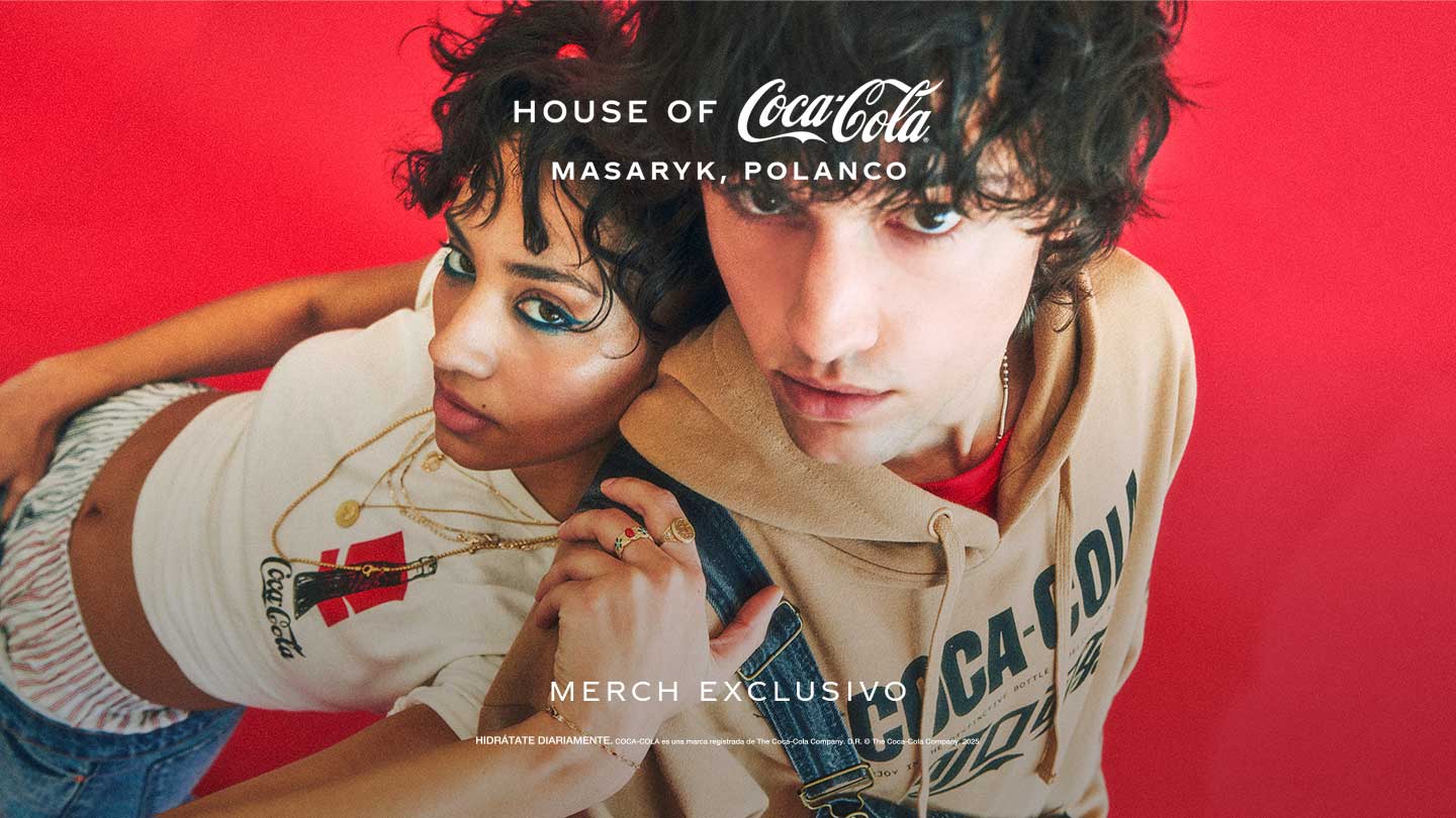 Dos personas jóvenes usando prendas de merch exclusivo de House of Coca-Cola, sobre fondo rojo, en una sesión de estilo editorial.​