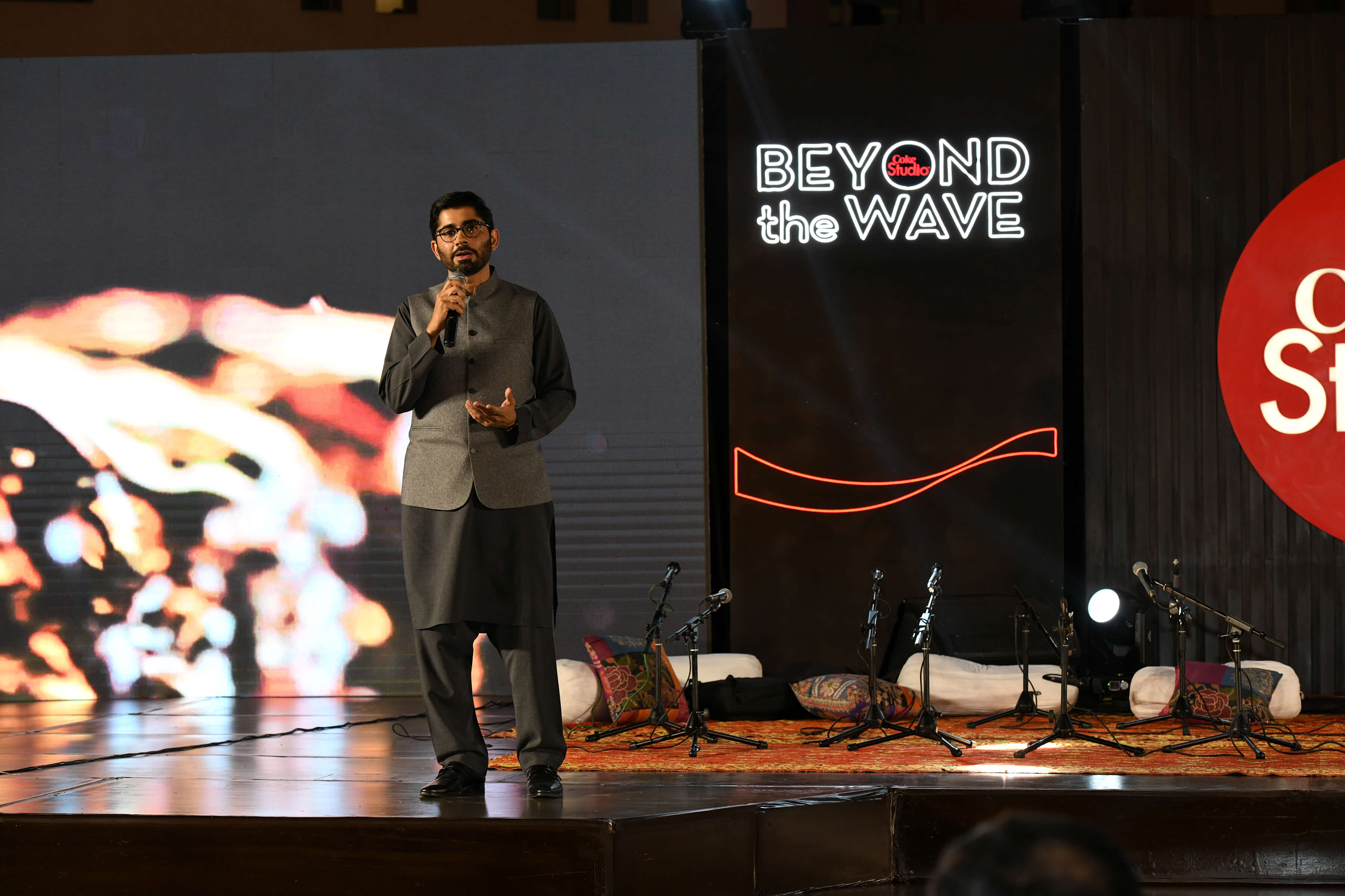 اسٹیج پر آدمی مائیکروفون میں بول رہا ہے