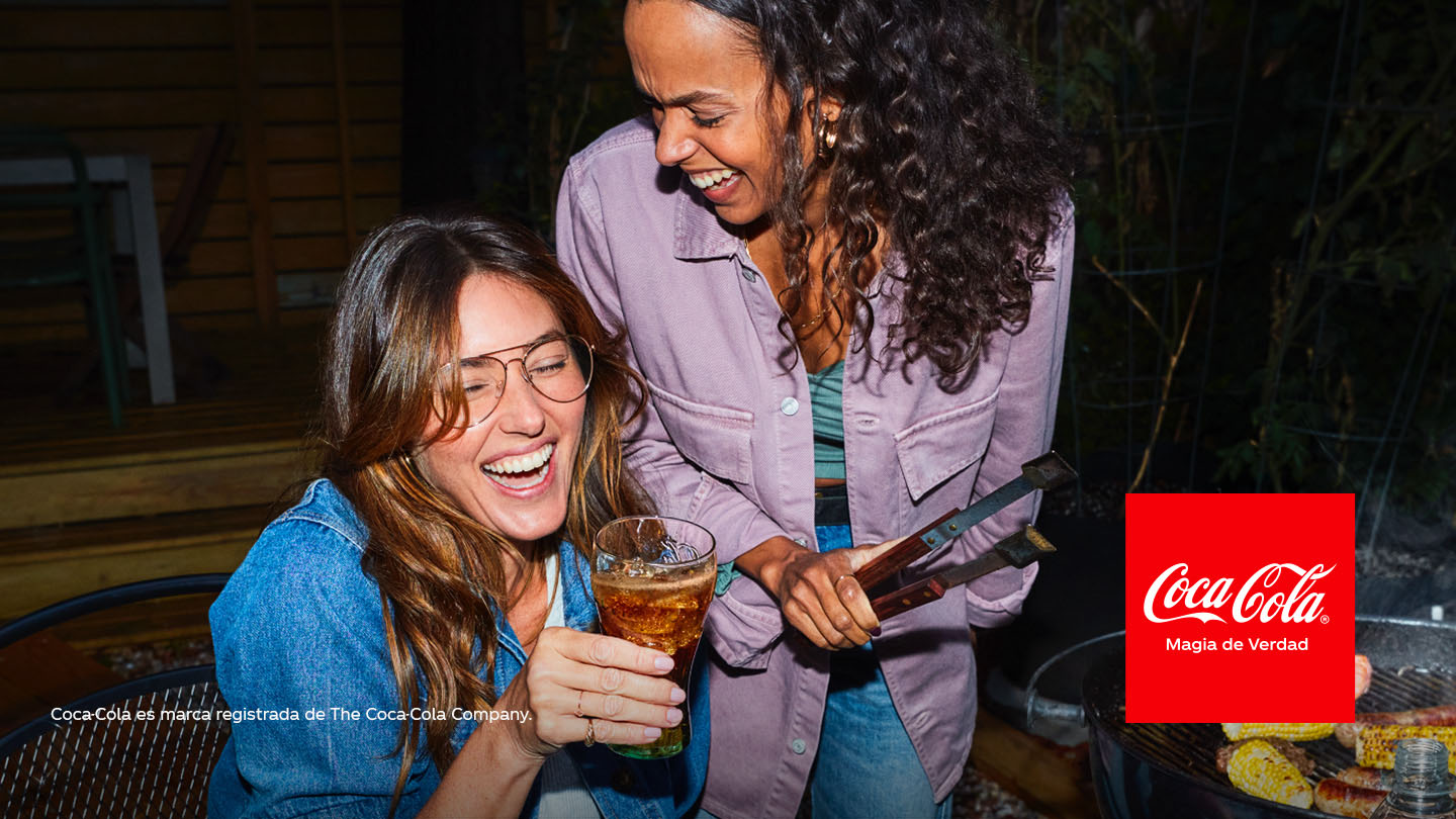 Dos mujeres ríen en una parrillada.