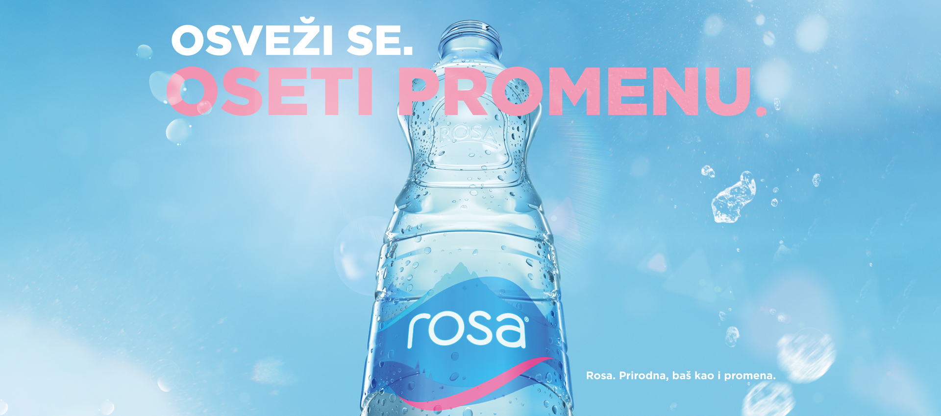 Flaša vode „Rosa“ na svetloplavoj pozadini sa kapljicama i mehurićima, uz tekst „Osveži se. Oseti promenu.“ i slogan „Rosa. Prirodna, baš kao i promena.“