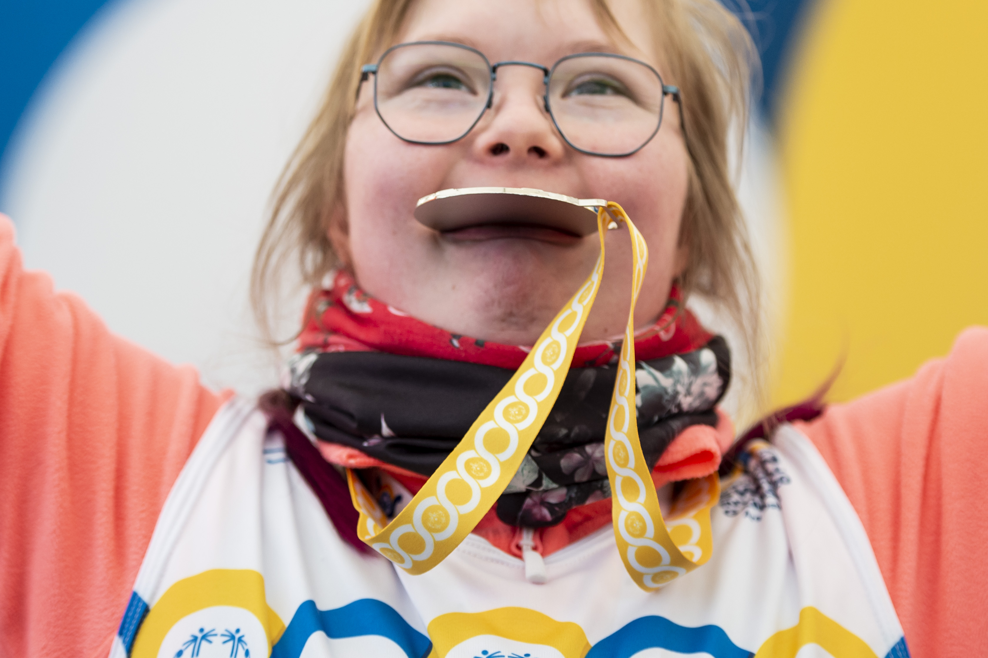 Person med sporttröja och ett gult medaljband runt halsen.