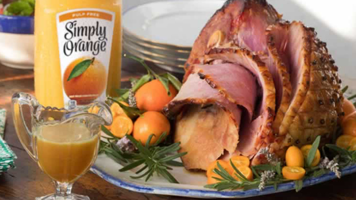 A dining table with food and a Simply Orange bottle