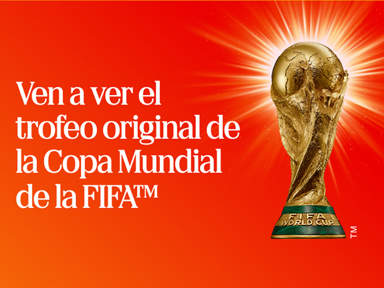 Trofeo original dorado de la Copa Mundial FIFA brillando sobre fondo naranja con texto que invita a ver la gira del trofeo.