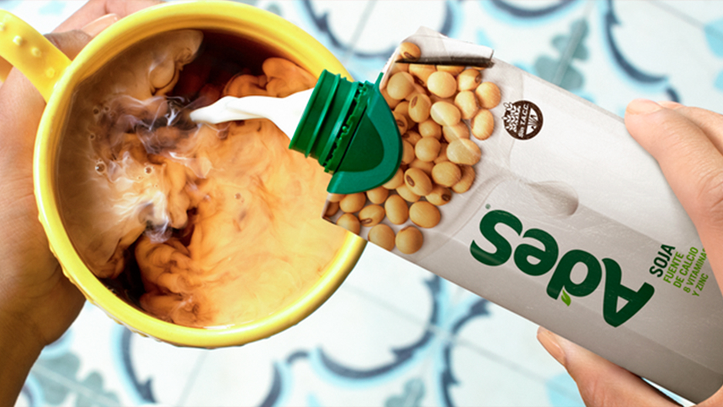 Mano vertiendo Tetra Brik Ades en una taza